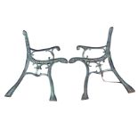 A pair of cast iron bench ends with scrolled decoration to chanelled frames, having scrolled arms