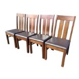 A set of four oak dining chairs with rectangular slatbacks above leather padded upholstered seats,