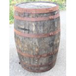 An oak whiskey barrel, the staves bound by six riveted metal strap bands. (43.75in)