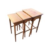 A nest of three rectangular oak tables, the primary table crossbanded in walnut framed by