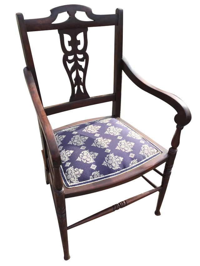 A stained Edwardian armchair with pierced fretwork splat to back, having scrolled arms on baluster
