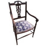 A stained Edwardian armchair with pierced fretwork splat to back, having scrolled arms on baluster