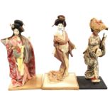 Two porcelain style Japanese geisha type costumed ladies on rectangular plinths; and another