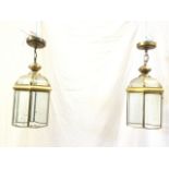 A pair of brass hall lanterns, the hexagonal enclosures with bevelled glass panes and domed tops,