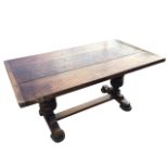 A stained refectory table with three-plank cleated top on twin bollection carved columns, raised