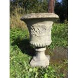 A large composition stone campana style urn, with moulded overhanging egg & dart rim above a waisted