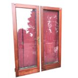A pair of plate glass hardwood patio doors with rectangular double glazed panels and brass
