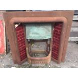 A late Victorian cast iron fire insert, the cushion moulded frame with shell embossed corners fitted
