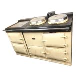 A four oven oil fired Aga, the cream enamelled stove with warming plate and two circular hinged