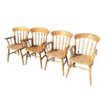 A set of four beech spindleback farmhouse armchairs with arched rails and solid seats raised on