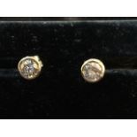 A pair of 18ct gold diamond stud earrings, the circular bezel set stones weighing I.75 carats,