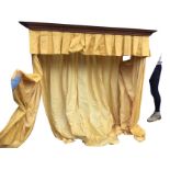 An oak canopy by Smallbone with suspended cornice above a box pleated lemon yellow damask pelmet and