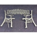 A gold painted cast iron garden bench with arched latticework back panel and channelled ends with