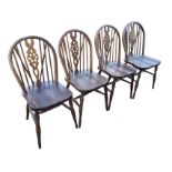 A set of four wheelback dining chairs with hoops on spindles framing pierced splats, the solid seats