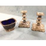 A pair of square old Sheffield plated candlesticks with foliate scrolled borders - filled; and a