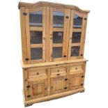 A reproduction pine dresser, the arched back with three glazed doors enclosing shelves, the base