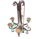 A rusty old wrought iron hanging candlelight with six scrolled branches supporting candleholders (