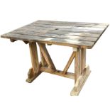 A rectangular garden table with slatted wood top on trestle style supports with sledge feet, the top