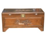 An oriental carved camphor wood blanket box, the fielded panels with figural cityscape scenes,