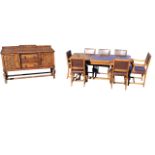 A carved oak dining room suite with sideboard, draw-leaf dining table and seven dining chairs with