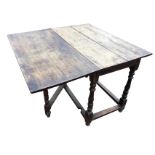 A nineteenth century oak dining table, the rectangular top with drop leaf on hinged gate, raised