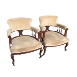 A pair of late Victorian mahogany captain style armchairs, the rounded upholstered backs on spindles