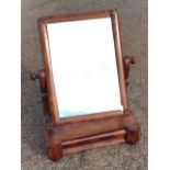 A Victorian mahogany dressing table mirror having cushion moulded frame on shaped supports, above