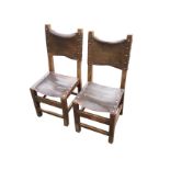 A pair of oak side chairs with leather backs and seats having copper studding, raised on square