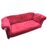A late Victorian button upholstered chesterfield sofa with padded back and drop-arm, the sprung seat