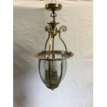 An octagonal glass hall lantern with bevelled glass panes enclosing three candlights, supported by