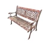 A rectangular garden bench having cast iron scrolled back panel above a slatted seat, with