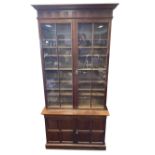 A tall Edwardian walnut library bookcase, with moulded cornice above a fluted frieze having reeded