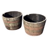 A pair of oak garden plant tubs, the cut barrels bound mount by riveted metal strap bands. (35.5in x