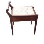 A C20th stained piano stool with tapestry upholstered box seat flanked by a turned handle, raised on