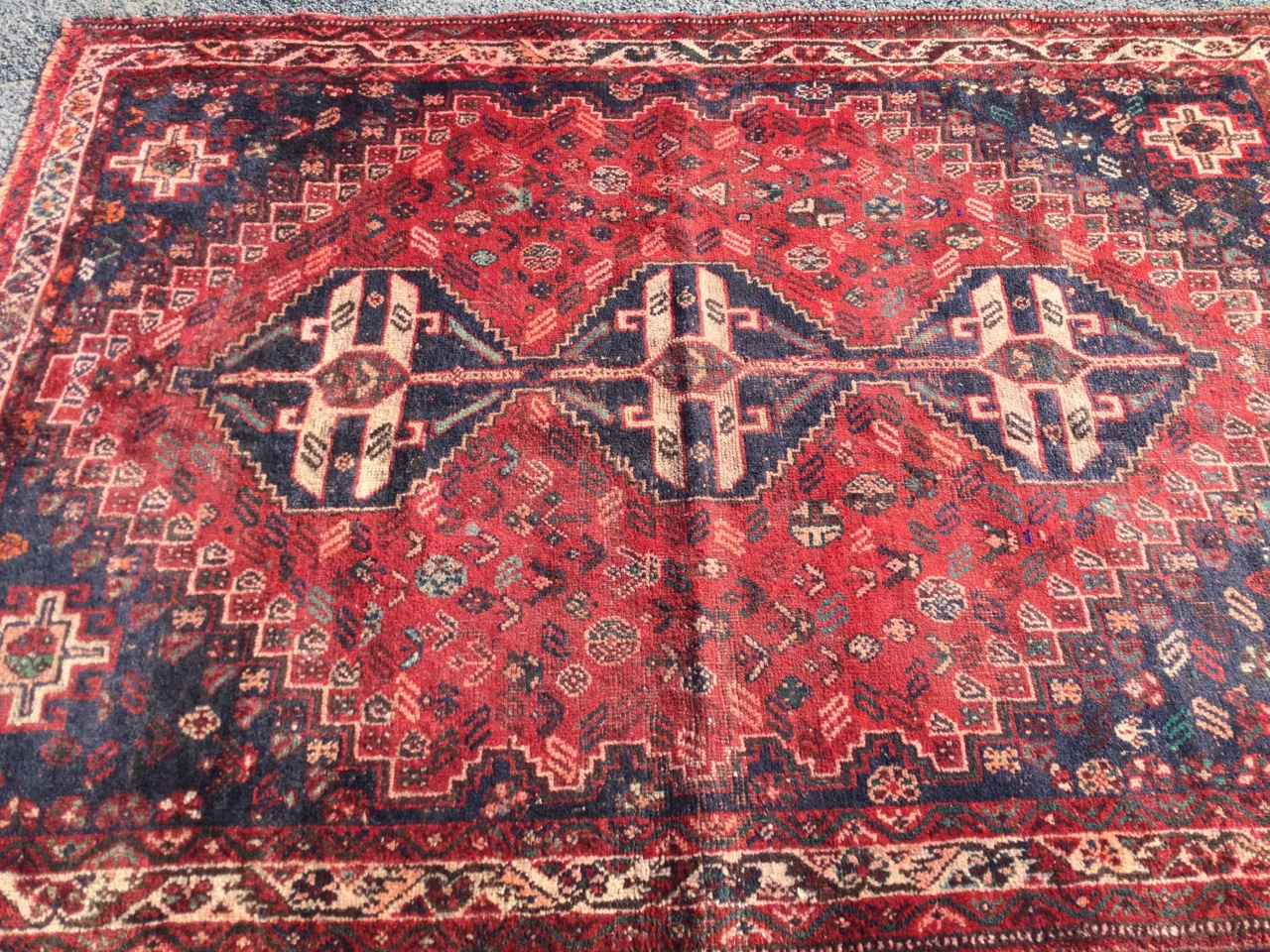 An oriental bokarra rug woven with three linked serrated blue medallions on red field with floral - Image 2 of 3
