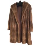 A ladies lined mink coat with wide collar and cuffs.