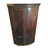 A nineteenth century bowfronted mahogany corner cabinet with moulded dentil cornice above boxwood