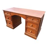 An oak kneehole desk by Smallbone, with rectangular top above an arched frieze apron and two