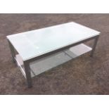 A contemporary acid etched plate glass topped coffee table, with plain glass platform stretcher