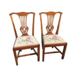 A pair of Chippendale style mahogany dining chairs with pierced splats above floral needlework