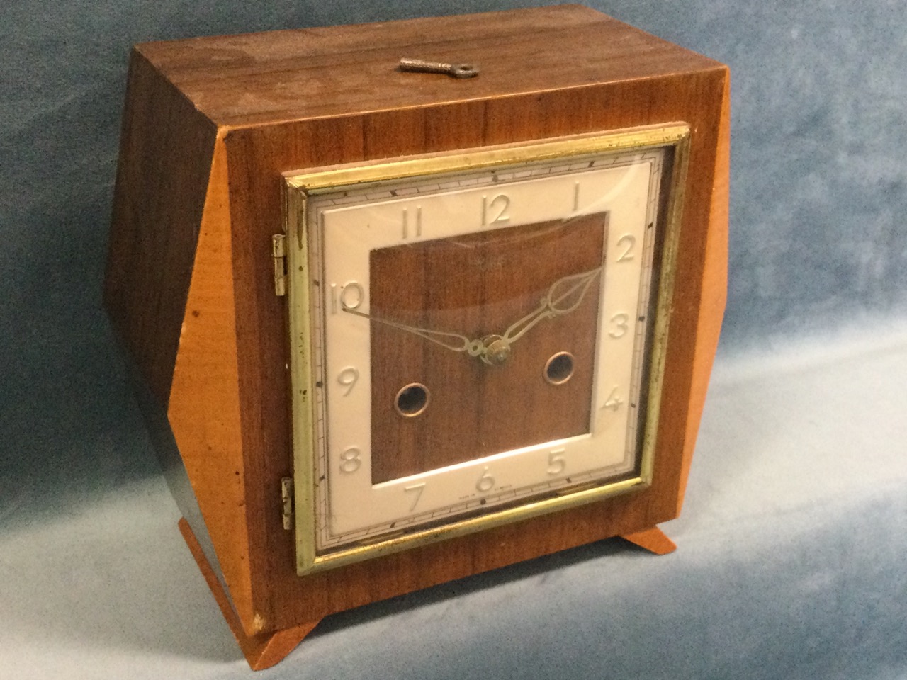 A deco walnut cased mantleclock with square dial under convex glass with brass frame, the Smiths