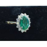 An 18ct gold emerald and diamond ring, the oval claw set emerald of over 2.75 carats, framed by a