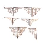 Five-and-a-half pairs of cast iron shelf brackets, the supports with pierced scrolled decoration -