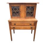 A walnut secretaire with two fretwork glazed doors to top above a fold-over desk on lopers, with two