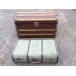 A canvas covered wood motoring trunk, the rounded case with leather handle and painted metal mounts;
