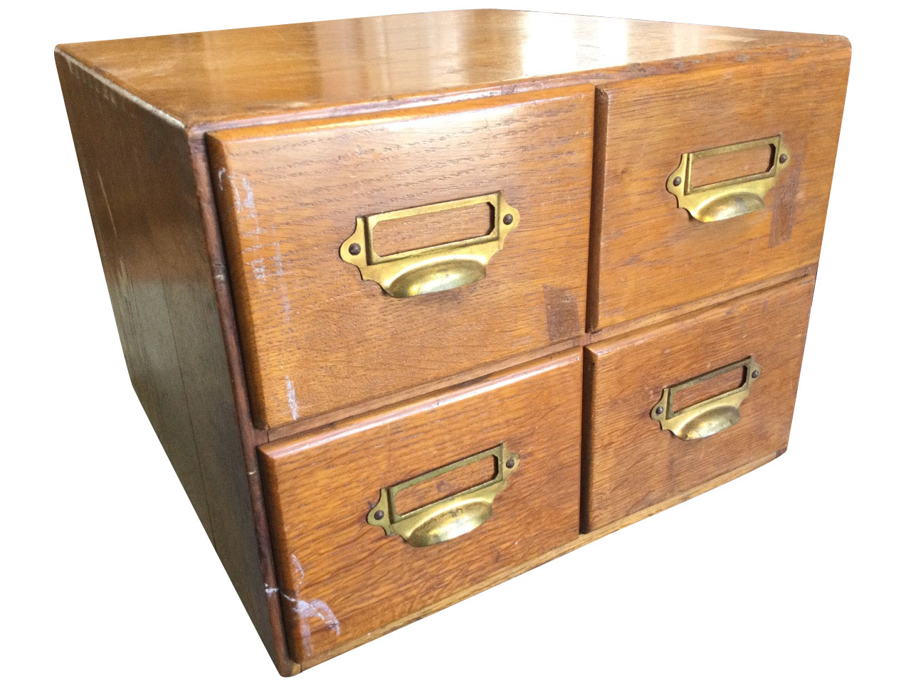 An Edwardian oak card index cabinet, with four drawers mounted with brass cup handles and label-