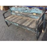 A painted bench seat with shaped moulded back and downswept arms framing a plank seat, raised on