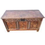 An eighteenth century oak coffer with rectangular moulded two-plank top above an arcaded leaf carved