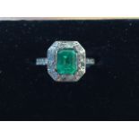 A large emerald and diamond ring on 9ct white gold band, the rectangular baguette cut emerald