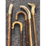 A weighted fishermans wading stick with ribbed horn handle; two carved horn handled walking sticks